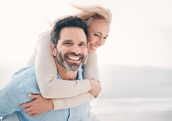 Image showing Beach, piggyback and portrait of couple with smile on holiday, vacation and weekend for anniversary. Love, marriage and happy mature man carry woman for bonding, quality time and happiness by ocean