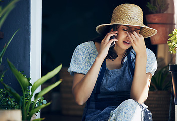 Image showing Mental health, woman florist with headache and with smartphone on a phone call with a client at her workplace. Anxiety or stress, sad and female person talking on a cellphone for customer service.