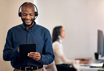 Image showing Call center, tablet and man online for customer service, crm or telemarketing support. Black person, consultant or agent with a smile and technology for online sales, contact us or help desk advice