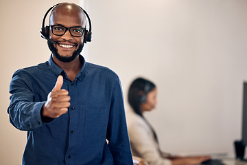 Image showing Call center, thumbs up and a man smile for customer service, crm or telemarketing support. Black person, consultant or agent with headset and yes emoji or hand sign for sales, contact us or help desk