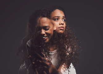 Image showing Depression, mental health and woman in studio with stress, identity crisis or bipolar disorder. Horror, psycho and female person with trauma or anxiety browsing on a phone by a dark black background.