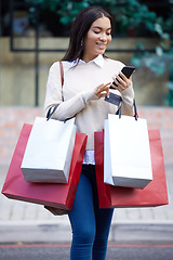 Image showing Shopping, retail and woman with phone in city for sale, discount and bargain notification. Fashion store, mall and happy female person on smartphone for purchase, buying and promotion news online