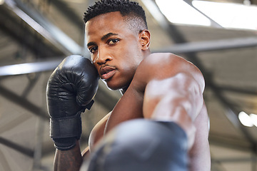 Image showing African man, boxing and punch in portrait for fitness, focus or training at gym for growth, goal and competition. African guy, boxer and gloves for exercise, wellness and martial arts club for sports