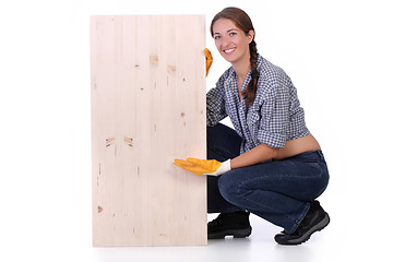 Image showing woman carpenter holding wooden plank