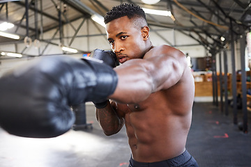 Image showing African man, boxing and punching in gym for fitness, focus or training for growth, goal and health for competition. African guy, boxer and gloves for exercise, wellness or martial arts club for sport