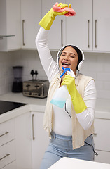 Image showing Woman with headphones, singing while cleaning and chemical bottle as mic with fun and music, hygiene and house work. Young female cleaner, housekeeping and enjoy listening to radio, dancing and clean