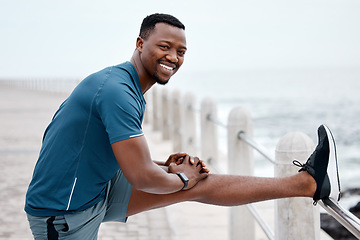 Image showing Stretching, fitness and portrait of black man by ocean for exercise, marathon training and running. Sports, nature and happy male person stretch legs for warm up, cardio workout and wellness by sea