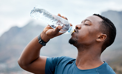 Image showing Drinking water, fitness and black man in nature for exercise, marathon training and running outdoors. Sports, workout and thirsty male person rest to drink liquid for hydration, wellness and health