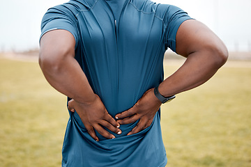 Image showing Man, fitness and back pain after running exercise, cardio workout or training on grass field outdoors. Rear view of male person, athlete or runner with sore spine, injury or bone inflammation outside