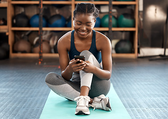 Image showing Happy black woman, fitness and phone for social media, communication or networking at the gym. African female person or athlete typing, texting or chatting on mobile smartphone after workout exercise