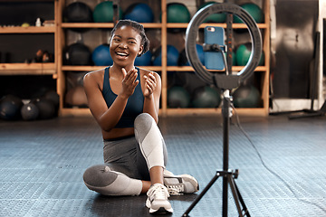 Image showing Fitness, woman and phone blog for live stream exercise at gym on platform or app. Influencer, training or health vlog with black person or coach talking to social media or virtual audience with light