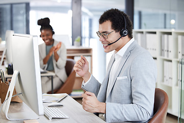 Image showing Call center, man and celebrate success with headset and computer at telemarketing or customer service desk. Male agent or consultant excited for bonus, target goal or deal in crm, support or sales