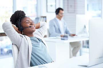 Image showing Call center, woman and relax with headset and computer on desk for telemarketing or customer service. Black female on break with smile for complete, finish or productivity in crm, support or sales