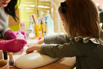 Image showing Little girl is getting manicure in beauty salon, close-up.