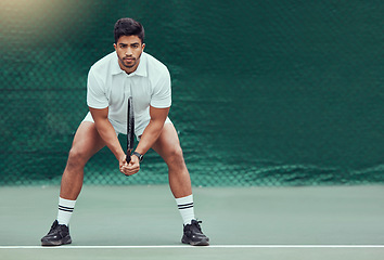 Image showing Sports, space and man at court for tennis, training and mockup, mindset and focus on green background. Fitness, workout and Indian male player with racket for match, competition and body exercise