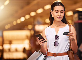 Image showing Credit card, phone and a woman with a shopping bag in mall for fashion, sale or discount deal. Female person or happy customer with retail bag for online promotion offer and mobile banking app mockup