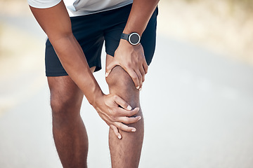 Image showing Running, knee pain and closeup of man in city for inflammation, accident and emergency. Fitness, workout and training with legs of male runner in road for muscle ache, sports injury and first aid