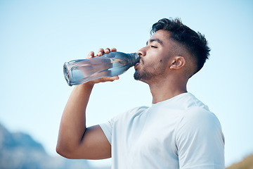 Image showing Man, fitness and drinking water in nature exercise, cardio workout or running for sustainability outdoors. Thirsty male person, athlete or runner with drink for hydration, rest or break on mountain