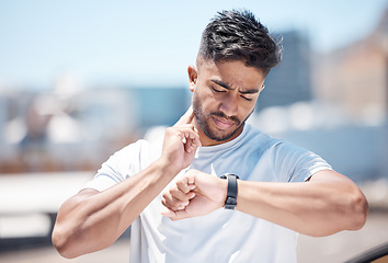 Image showing Man, fitness and checking watch for pulse, heart rate or performance after running exercise in city. Fit, active and sporty male person, athlete or runner looking at wristwatch for monitoring in town