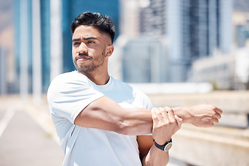 Image showing Man, fitness and stretching arms in city for running, cardio workout or exercise in the outdoors. Fit, active or sporty male person, athlete or runner in warm up arm stretch before training in town