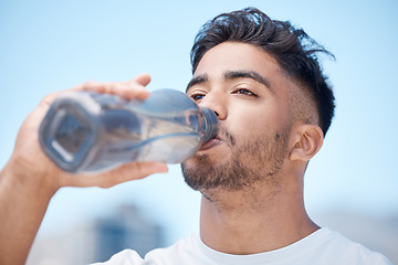 Image showing Man, fitness and drinking water in city for sustainability after running exercise, workout or training outdoors. Thirsty male person, athlete or runner with drink for hydration, rest or break in town