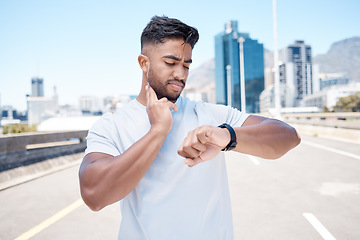 Image showing Fitness, man and watch in city for pulse, heart rate or checking performance after workout or exercise. Fit, active and sporty male person, athlete or runner looking at wristwatch for cardio health