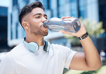 Image showing Man, fitness and drinking water in city exercise, cardio workout or running for sustainability outdoors. Thirsty male person, athlete or runner with drink for hydration, rest or break in urban town