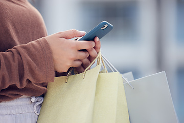 Image showing Shopping, phone and hands of woman in city with bag online for bargain notification, social media and internet. Retail, fashion and female person on smartphone for chat, mobile app and website sale