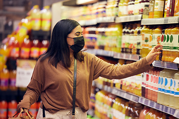 Image showing Grocery shopping, woman and juice at a shop, market and store for groceries sale with mask. Health, virus safety and female person with orange and healthy drink purchase in a supermarket at shelf