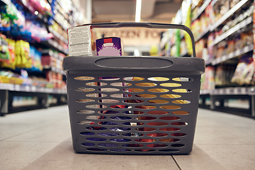 Image showing Closeup of basket with groceries, floor with shopping and supermarket, food product with retail and stock. Grocery choice, store shelf and aisle with merchandise, commercial service with shop sale