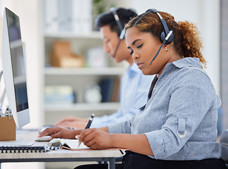 Image showing Telemarketing, business woman and contact us writing in a office with paperwork at desk. Call center, African female employee and consulting of a worker with web support and agent advice notes