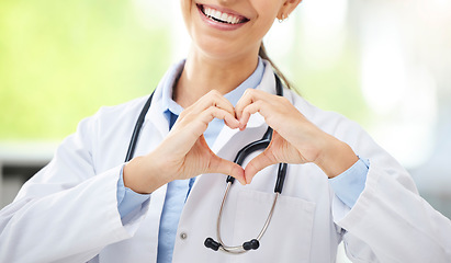 Image showing Love, woman doctor with heart sign and with smile at a hospital for healthcare. Medication or health wellness, nurse and support hand emoji with a female surgeon with stethoscope at a clinic.