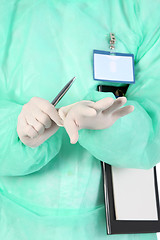 Image showing surgeon putting medical gloves on