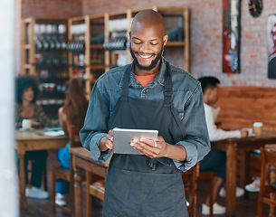 Image showing Restaurant, tablet and happy man or small business owner, e commerce and online cafe or coffee shop management. Waiter or african person reading sales on digital technology or internet for startup