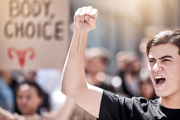 Image showing Protest, rally and man with fist raised for freedom, human rights or equality outdoor in city. Speaker with community people hands, poster or sign to shout for politics, change or reproductive choice