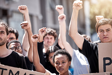 Image showing Protest, rally and people fight together for freedom, human rights or equality outdoor in city. Diversity men and women or community with fist, poster and hands for politics, change or social justice