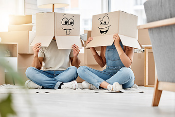 Image showing Funny, couple moving and boxes on head with faces, smile or emoji drawing on cardboard and new house, property or real estate. People, comic and box on body with happiness, crazy or joke in home