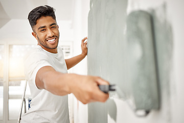 Image showing Man, renovation and painting a home wall in DIY, house project or maintenance or construction, interior design and decoration. Paint, bedroom or remodel space with paintbrush, roller and painter