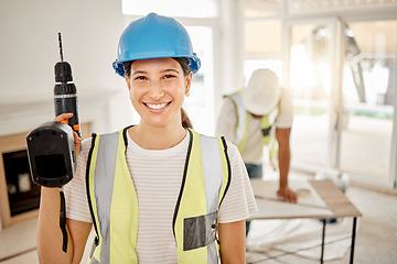 Image showing Portrait of woman, construction and home renovation with drill, helmet and smile in apartment. Yes, positive mindset and diy renovations, happy female in safety in building project tools in new house