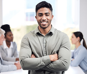 Image showing Portrait, smile and a business man arms crossed in the boardroom with his team planning in the background. Leadership, workshop and confidence with a happy young male employee standing in the office