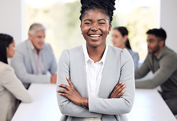 Image showing Portrait, smile and a business black woman arms crossed in the boardroom with her team in the background. Leadership, workshop and confidence with a happy young female employee standing in the office