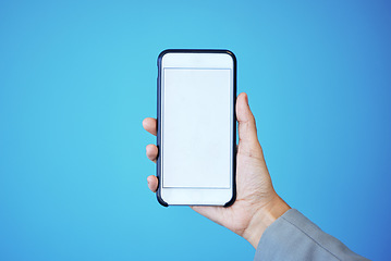 Image showing Person, phone and hand with mockup screen for advertising or marketing against a blue studio background. Hands, mobile smartphone or app with mock up, copy space or display for brand advertisement