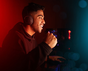 Image showing Man in dark room, video game and winning with fist pump, online streaming with gaming competition and esports. Neon lighting, cyber and male streamer celebrate win with gamer tournament and success