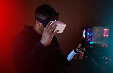 Image showing Man in dark room, gaming and VR goggles and controller, online streaming with video games and metaverse. Digital world, male streamer and future technology, games and virtual reality experience