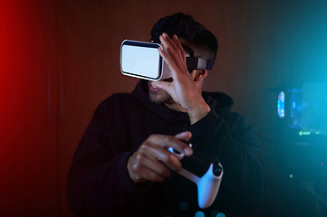 Image showing Man in dark room, video game with VR goggles and controller, online streaming with gaming and metaverse. Digital world, male streamer and future technology with games and virtual reality experience