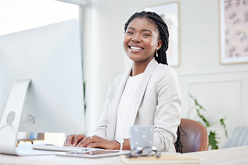 Image showing Happy, portrait of businesswoman typing and computer at her desk in a modern workplace office. Online communication, networking and African female accountant writing an email on pc at her workstation