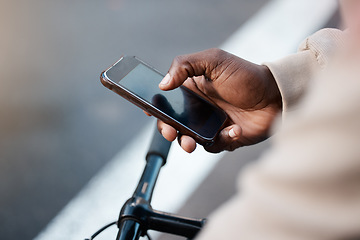 Image showing Man, hands and phone with screen on bicycle for social media, communication or networking on mockup in city. Closeup of male person typing or texting on bike with mobile smartphone in an urban town