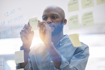 Image showing Brainstorming, writing and business man on glass board for planning, schedule and scrum or agile solution. Thinking, ideas and focus of African person on window sticky notes, job priority or reminder