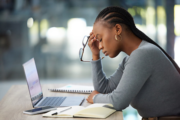 Image showing Mental health, businesswoman with headache and laptop at her desk in modern workplace office. Anxiety or burnout, problem or mistake and African woman stress or tired at her workspace with notebook