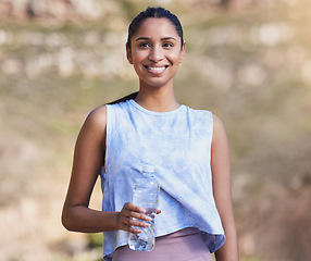Image showing Fitness, water and woman running in nature for race training by an outdoor mountain for health. Sports, exercise and female athlete with a bottle of liquid for hydration during a cardio workout.